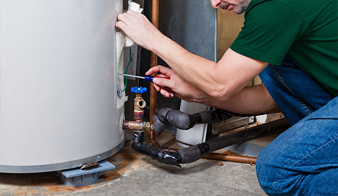 A technician is repairing a water heater