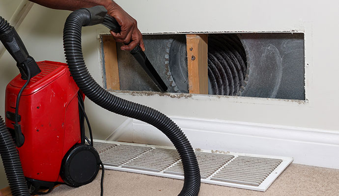 Professional air duct cleaning with industrial vacuum