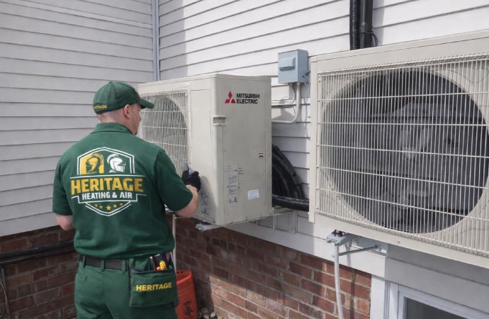 An HVAC technician installing outdoor condenser unit