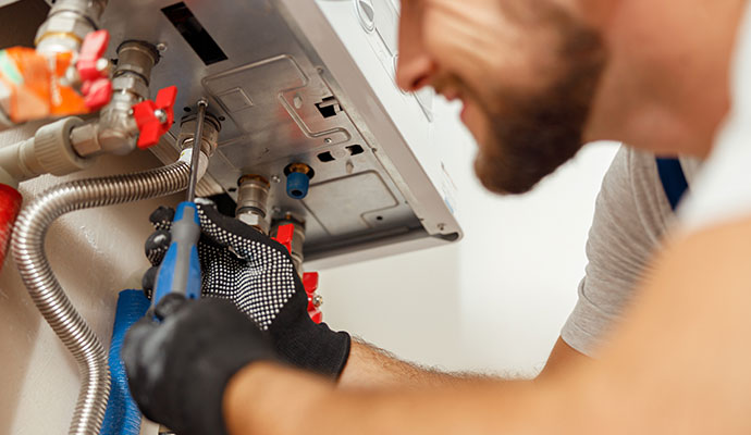 Technician servicing boiler connections