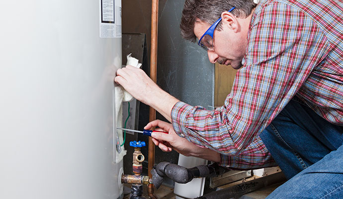 Technician inspecting electrical water heater connections