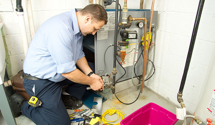 Technician performing forced air furnace maintenance