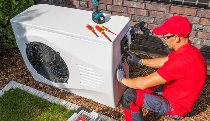 Technician installing outdoor heat pump unit