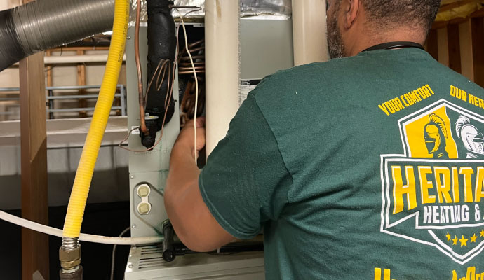 Heritage Heating and Air technician repairing heating system