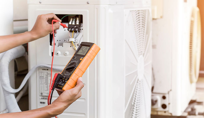 Technician testing AC electrical components