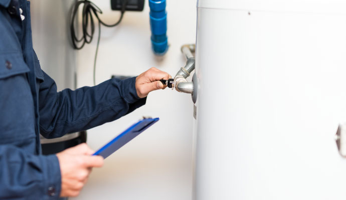 Technician adjusting gas water heater control valve