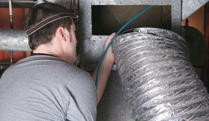 Technician cleaning duct system