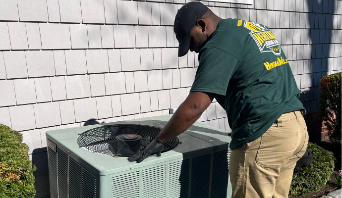 Technician inspecting outdoor HVAC unit